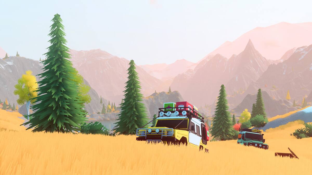 over the hill: two loaded off-road trucks cross a golden meadow below mountains